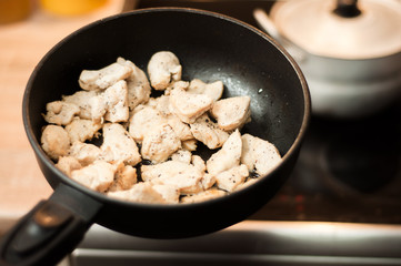 The process of cooking chicken breast diet for an athlete in a frying pan in sunflower oil. Meat for muscle recovery after exercise.