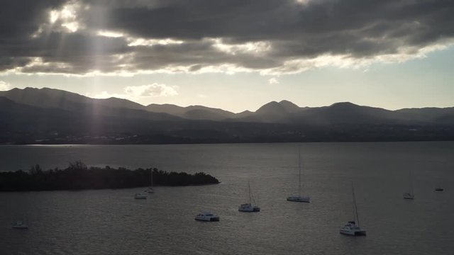A lot of sailboats in a calm water with mountain and clouds on background near Guadalupe island