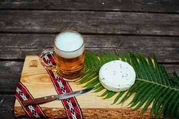 Latvian beer with latvian cheese and national folk belt