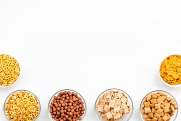 Various cereals in bowls on white background top view copyspace