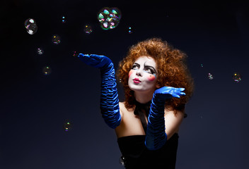 Woman mime with theatrical makeup and soap bubbles.