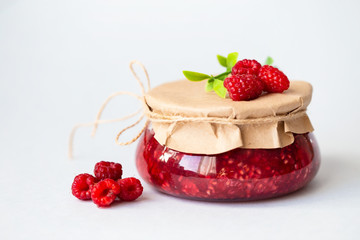 healthy fresh raspberries, homemade jam in a jar