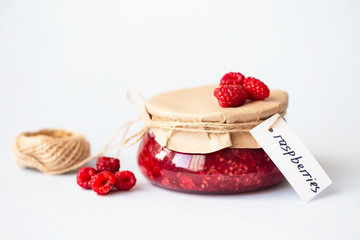 healthy fresh raspberries, homemade jam in a jar