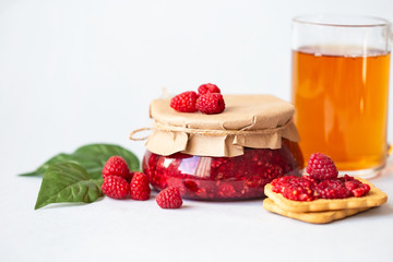 raspberries with sugar, healthy fresh raspberries, homemade jam in a jar, morning breakfast on a light background