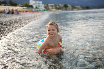 Funny child swim in sea with inflatable circle