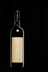 botella de vino tinto con etiqueta blanca en fondo negro