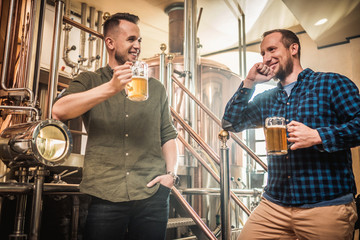 Fototapeta na wymiar Three men tasting fresh beer in a brewery