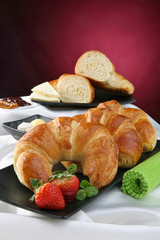 Still life with croissant, breakfast with pastry, fruit and jam.