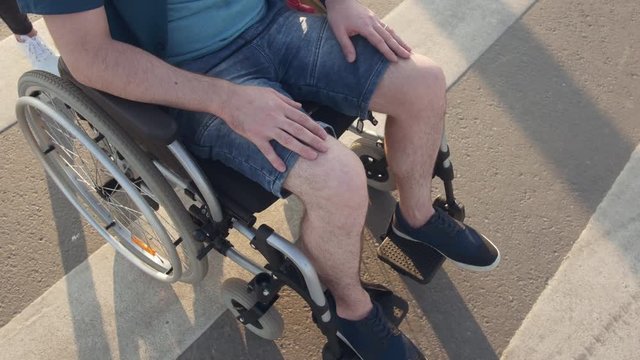 Desability man on wheel chair on pedestrian crossing. Close up.
