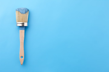 Brush tool in blue paint on blue background, copy space