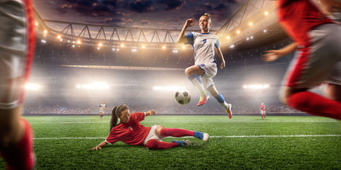 Female Soccer players performs an action play on a professional soccer stadium. Girls playing soccer