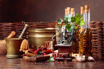 Various vintage cooking utensils with spices, seasonings and bottles of olive oil.