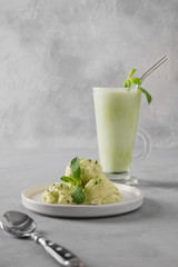 Green matcha ice cream and mint on grey table. Vertical orientation. Close up.