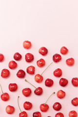 Sweet cherries on pink background, top view