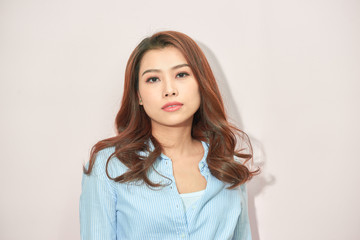 Obraz premium Beautiful lady in trendy blue blouse looking at camera with confident face expression while standing on light pink background