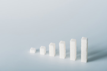 stacks of white sugar cubes on grey background with copy space