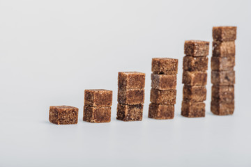 brown sugar cubes arranged in stacks on grey background