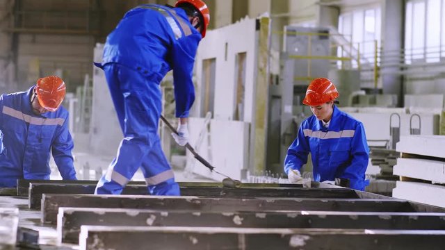 Panning shot of factory team doing finishing touches with cement panel