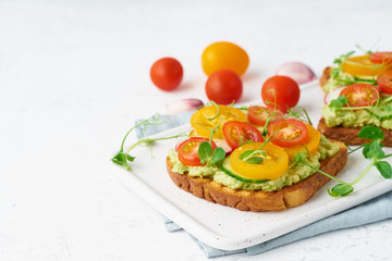 avocado toast with cherry tomatoes and herbs, breakfast, closeup, copy space