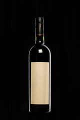 botella de vino tinto con etiqueta blanca en fondo negro