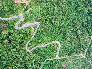Aerial view of curvy mountain road through a jungle