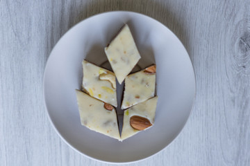Oriental dessert halva with pistachio, almond, cashew nuts, peanut, walnut  on a  plate. Image. Healthy food. Nuts mix assortment. sweets, Turkish Delight. Isolated  background.. Eastern delicacy