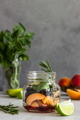 Ingredients for apricot and black currant lemonade (apricot, mint, rosemary and lime) on light grey background. Copy space. Top view.