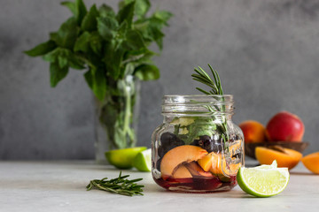 Ingredients for apricot and black currant lemonade (apricot, mint, rosemary and lime) on light grey background. Copy space. Top view.