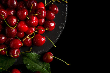 Sweet cherry. Sweet cherry on a dark background. Sweet cherry lies on the table. Drops of water on the cherry.
