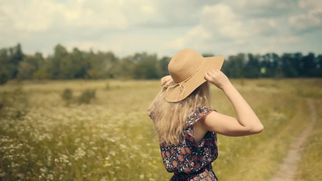 Romantic Female Walking.Girl Relaxing.Girl Walks Through Field.Pretty Ledy In Dress.Girl In Sunglasse. Enjoing.Happy Woman Walking In Summer Field.Wicker Hat.Woman In Hat Walking On Field.Woman In Hat