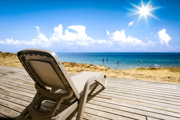 Summer chair on wooden terrace and beach landscape. Free space for your decoration and sunny day. 