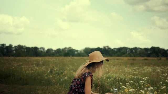 Woman Sniffing Flowers.Cheerful Girl Walking On Field.Beautiful Girl Sniffs  Flowers.Chamomile Flowers Field. Girl Enjoing Nature.Woman In Hat.Woman In Sunglasses.Portrait Pretty Ledy.Wicker Hat.