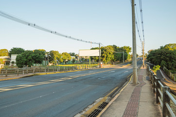 Brazilian large avenue with two ways, no cars, tactile floor and electric poles on sidewalk. Above the Pedro Chaves dos Santos viaduct of the Ceara Avenue at capital city, Campo Grande - MS, Brazil.