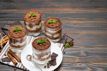 Classic tiramisu dessert in a glass on wooden background