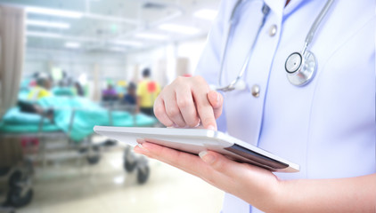 Doctor woman using tablet computer on blurred patient in emergency  room use  hospital background