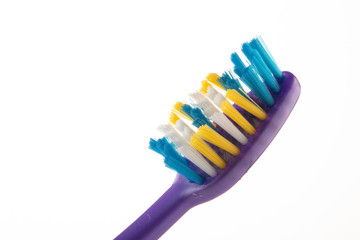 Purple toothbrush head on white background close-up