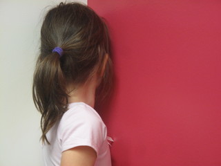 Girl with face to red wall