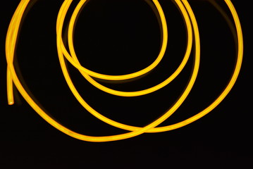 The original yellow lighting of thick electoluminescent wires and lines. Graphic abstract light background with interesting combination of shapes and textures.