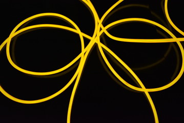 The original yellow lighting of thick electoluminescent wires and lines. Graphic abstract light background with interesting combination of shapes and textures.