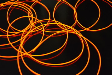 Glowing red material, thin bright threads. Burning wire, beautiful textural drawing of light. Art abstraction light fiber, tangle lines and abstraction.