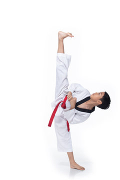 Master Red Belt Kid TaeKwonDo show basic step of fighting pose, Asian Teenager boy black hair tanned skin exercise warm up in white uniform bare foots, studio lighting white background copy space