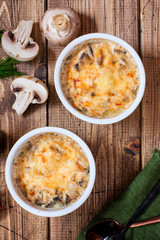 Chicken julienne and mushrooms in portion forms on a wooden table, selective focus