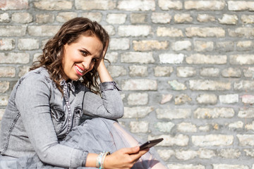 Young woman reading electronic book while sitting on bench