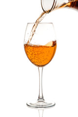 Amber wine in the glass. Wine is poured into a glass. Traditional Georgian wine according to ancient technology. Isolated on white background. Close up and vertical orientation.