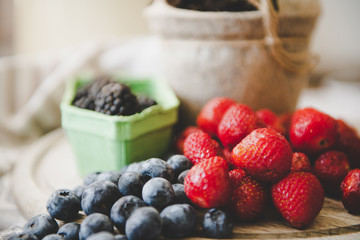 fresh strawberry blueberry and blackberry on wooden desk