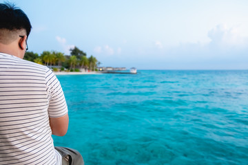 Fototapeta na wymiar relaxed man looking over the blue ocean in Maldives