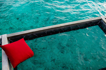 red pillow at net over sea in Maldives