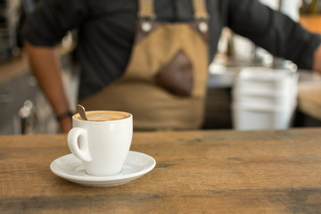 Cup of coffee on bar desk in pub.