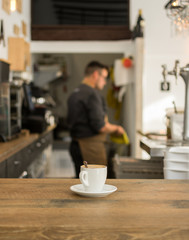 Cup of coffee on bar desk in pub.