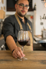 Waiter offering cup of wine in a pub
